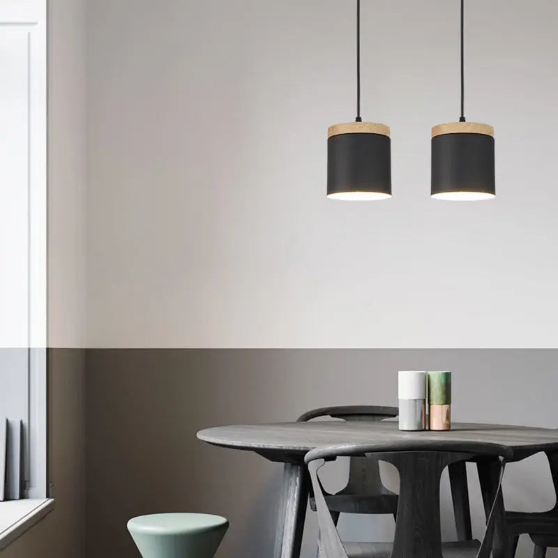 Modern dining area with a round table and chairs, featuring two black pendant lights.