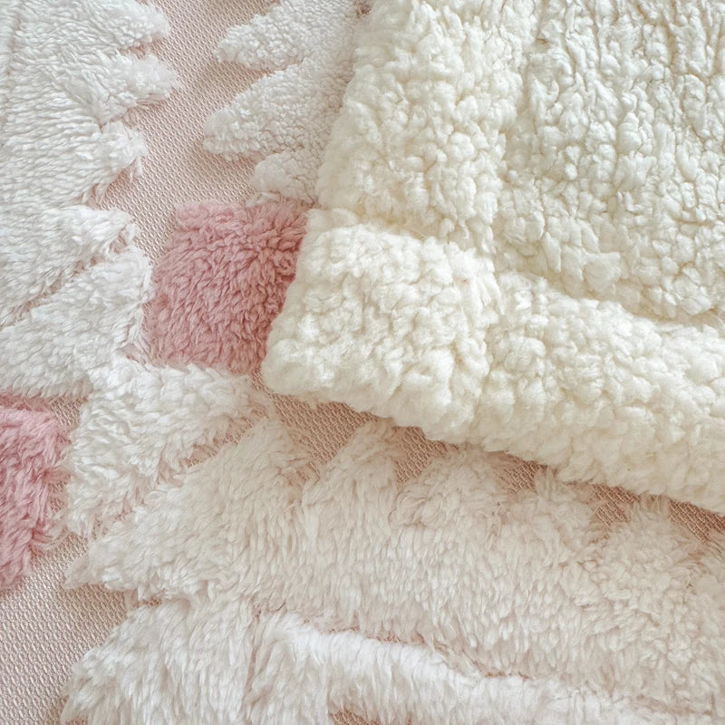 Close-up of textured white and pink fabric blanket.