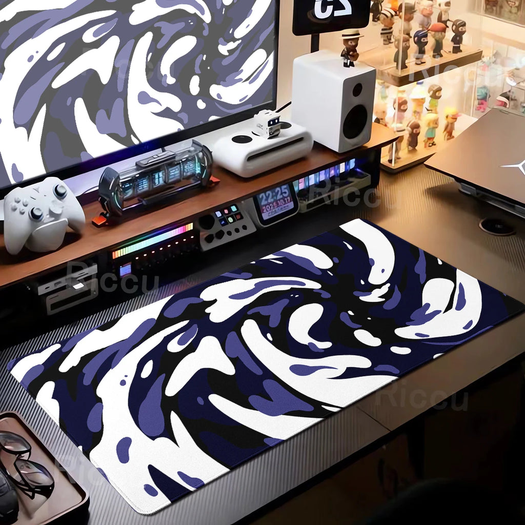 Desk setup with a blue and white abstract design mouse pad.