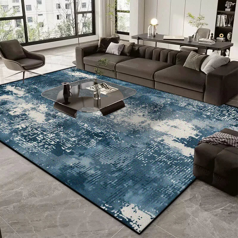 Living room with a blue abstract rug, gray sofa, and modern decor.