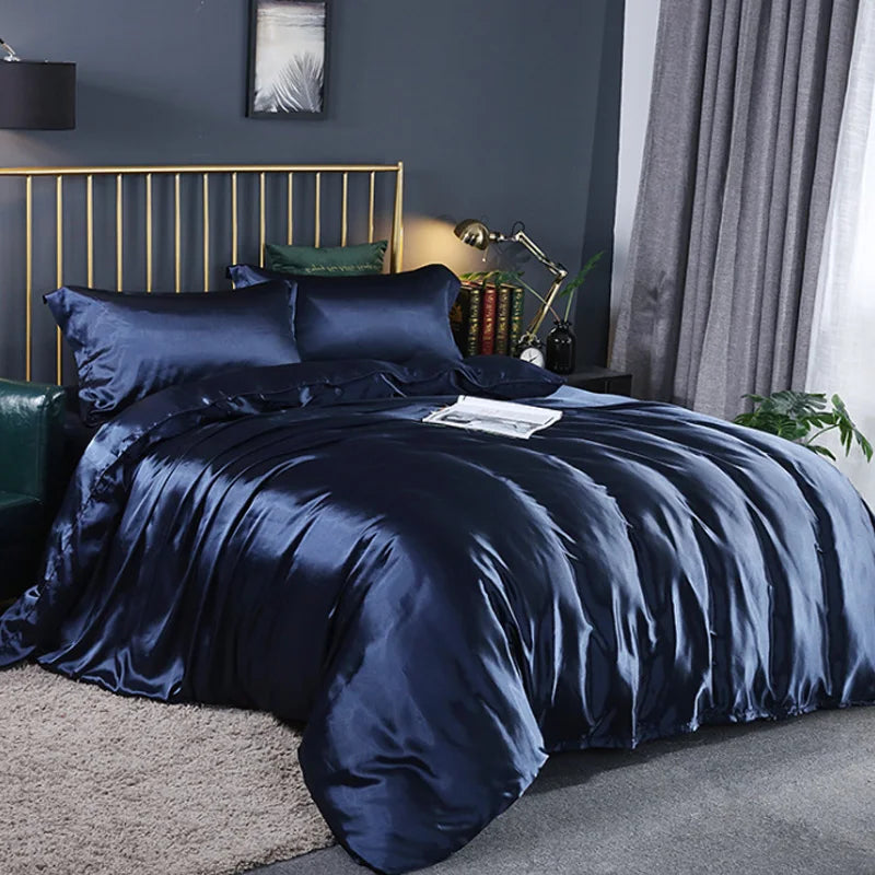 Navy satin bedding set on a bed in a bedroom with dark walls and a gold headboard.