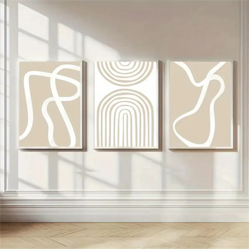 Three abstract line art canvases displayed above a beige sofa in a modern living room.