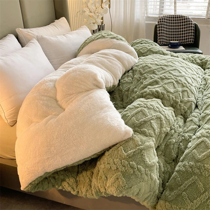 Green textured blanket draped over a bed with white pillows.