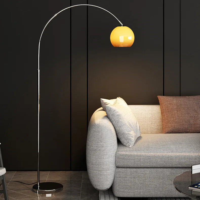 Adjustable Bauhaus floor lamp with a rounded mushroom glass shade styled next to a light grey sofa
