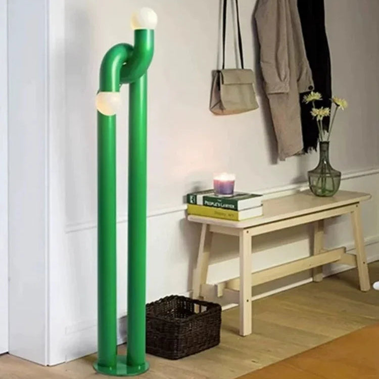 Modern interior with a green pipe-like lamp, wooden bench, and hanging coats.