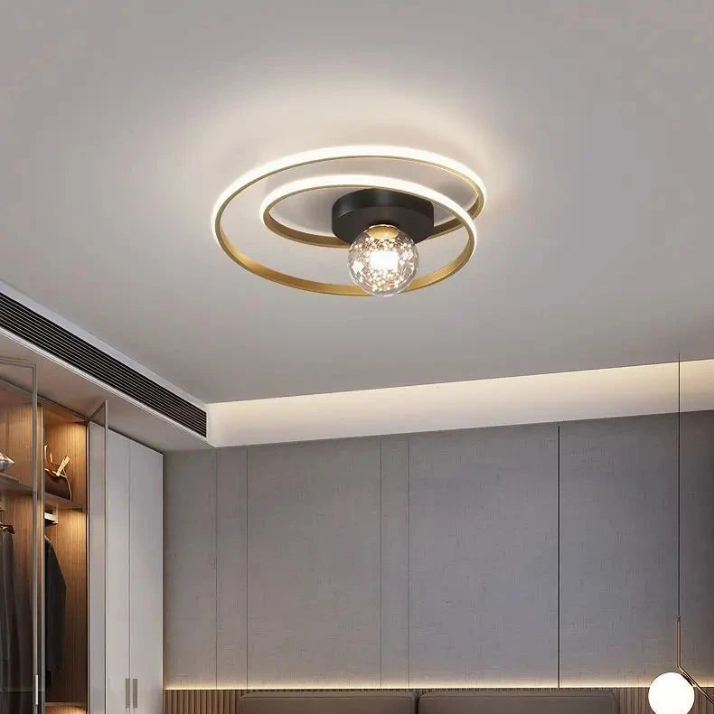 Close-up of black double-spiral LED ceiling light with textured amber glass globe against a white ceiling