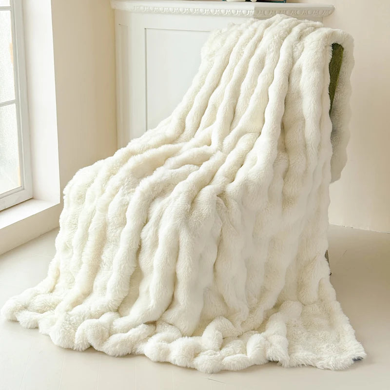 White textured blanket draped over a chair in a bright room with a window.