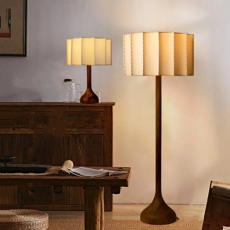 Two lamps, one on a table and one standing, in a room with wooden furniture.