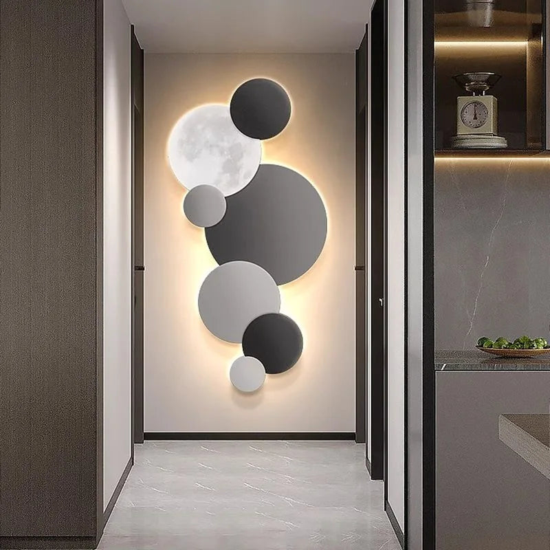 Black and grey moon-inspired LED wall light in a modern hallway