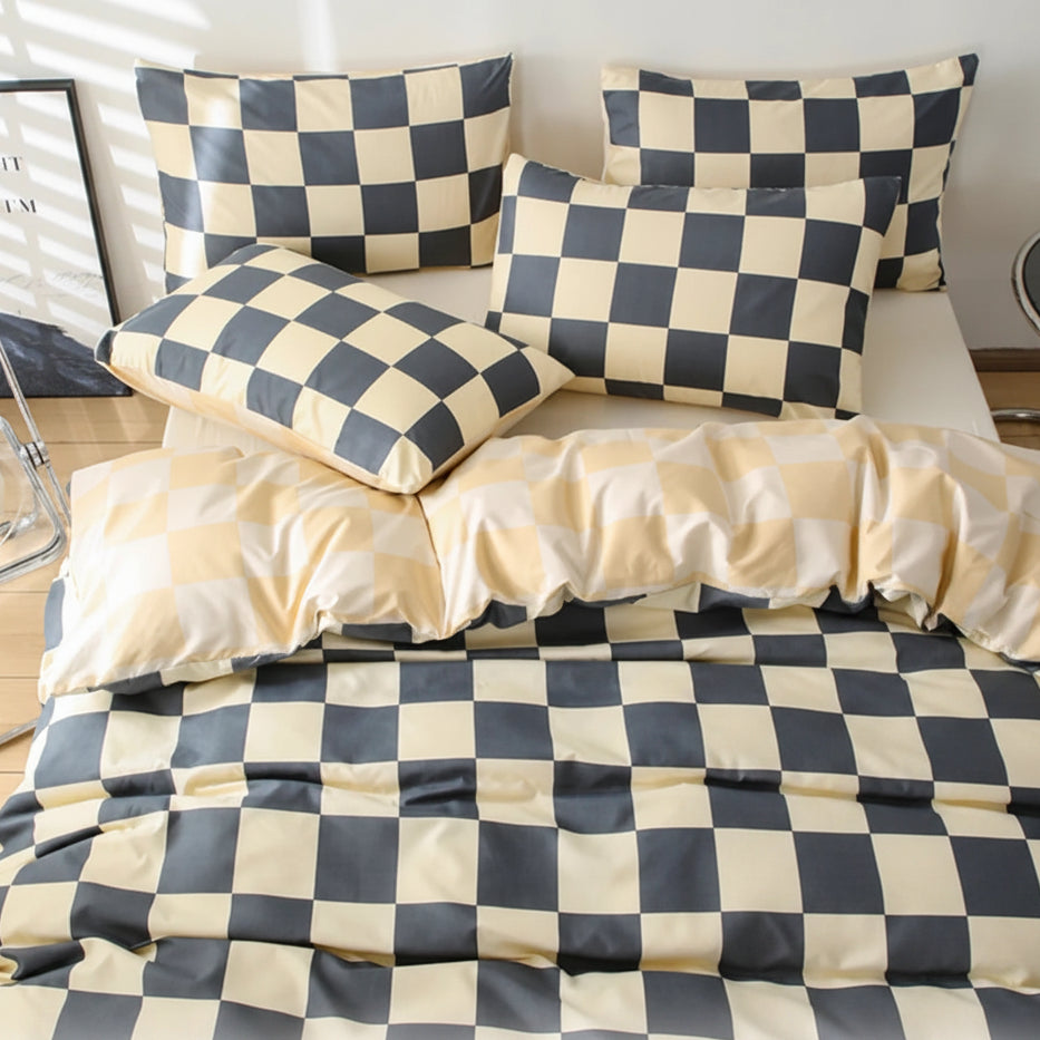 Checkered bedding set with pillows and a washing machine on a checkered floor.