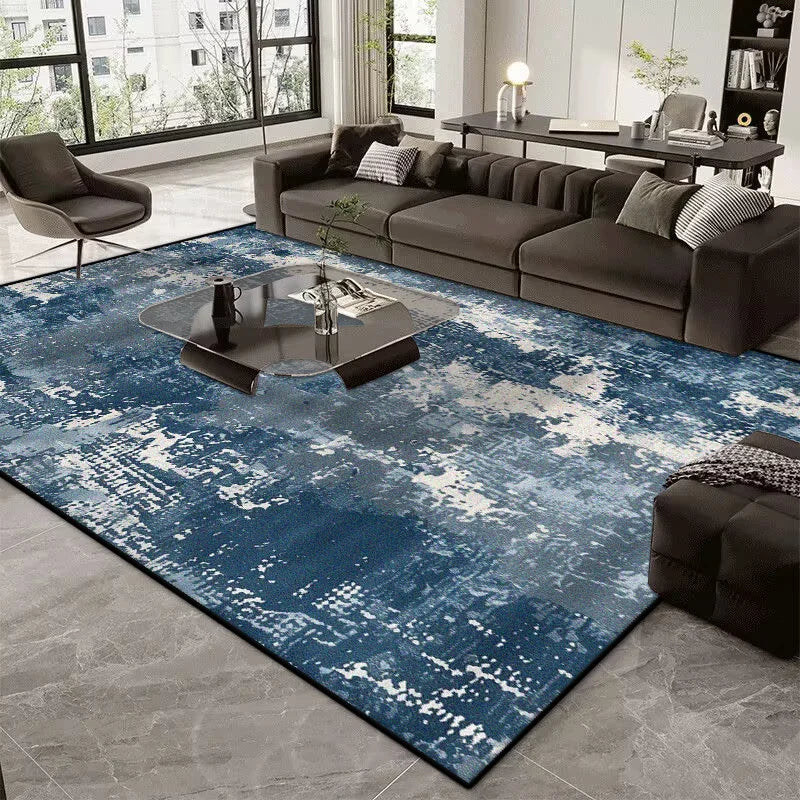 Living room with a blue abstract rug, gray sofa, and modern decor.