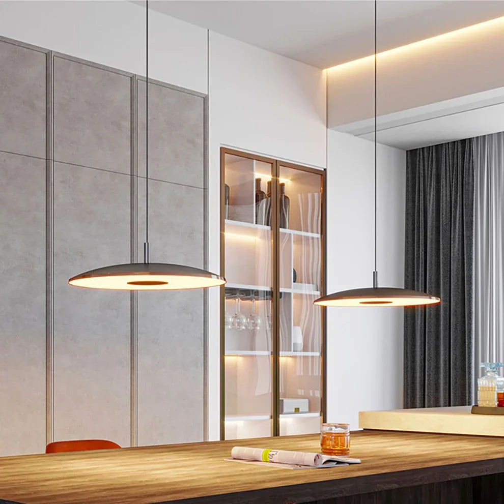 Modern office interior with a wooden desk, chairs, and pendant lights.