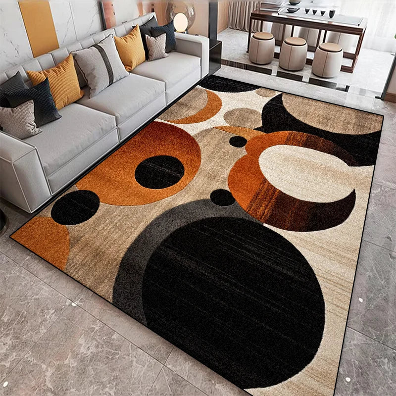 Abstract rug with circular orbit pattern in orange, black, and beige displayed next to a light grey sofa