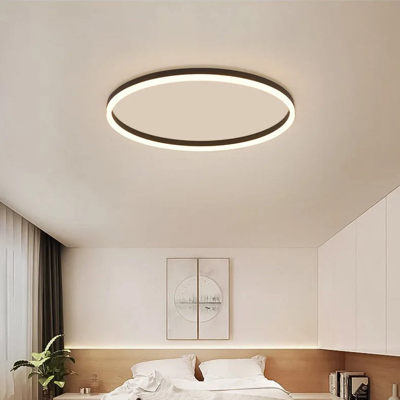 Black modern round LED ceiling light with warm circular glow and surface-mounted design.