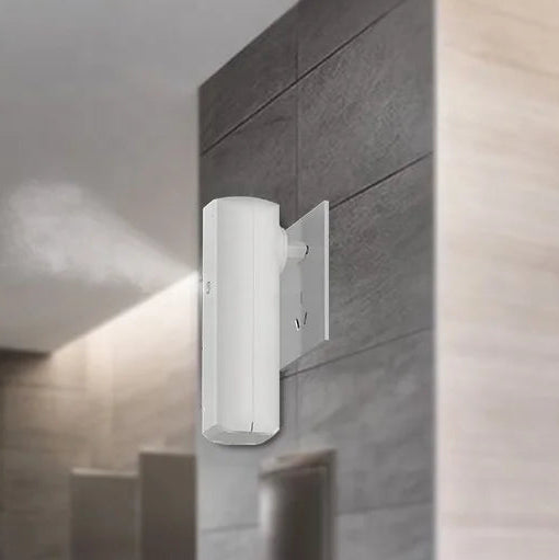Wall-mounted white plug-in electric diffuser installed on tiled wall