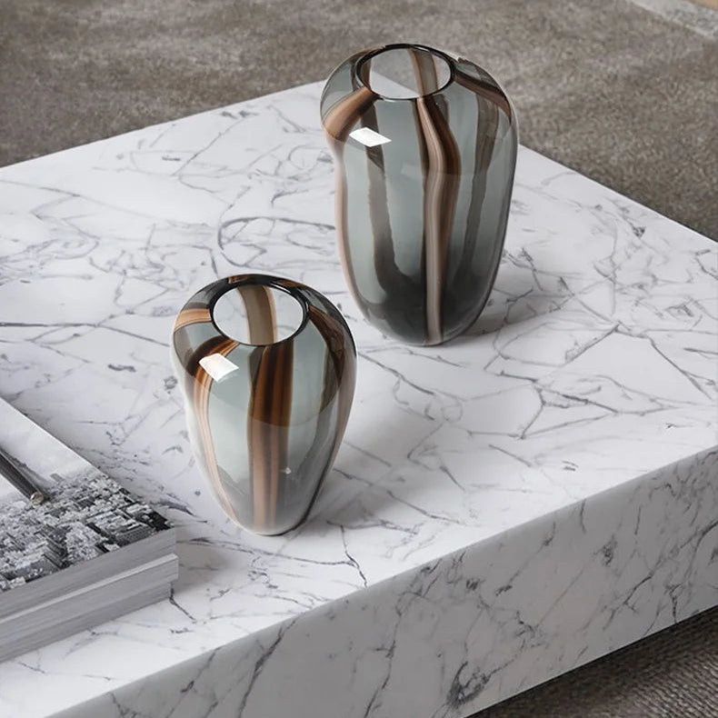 Two modern glass vases on a marble surface