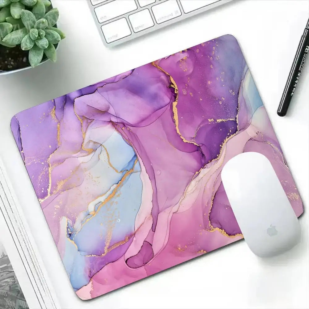 Mouse pad with a purple and pink abstract design on a desk with a keyboard and mouse.