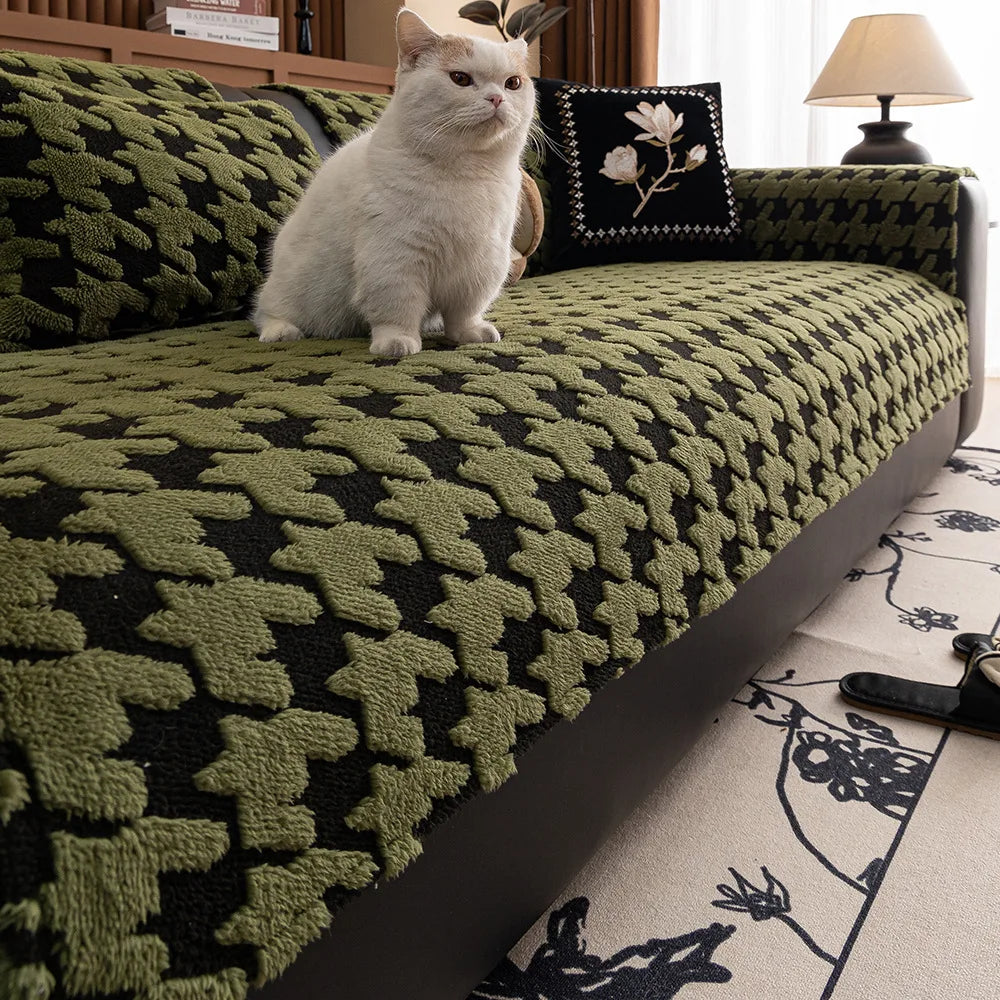 A green patterned sofa with a lamp and decorative pillow in the background.
