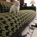 A green patterned sofa with a lamp and decorative pillow in the background.