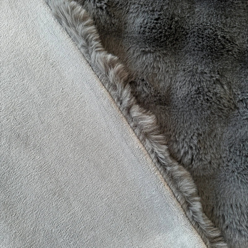 A charcoal coloured blanket with a textured border on a light grey background