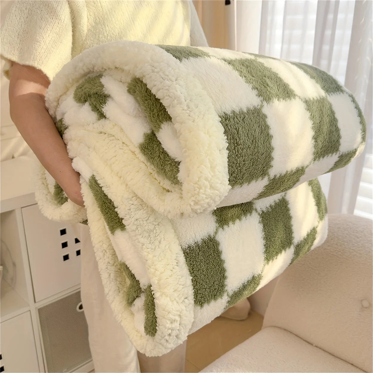 Green and white checkered blanket held by a person in a home setting