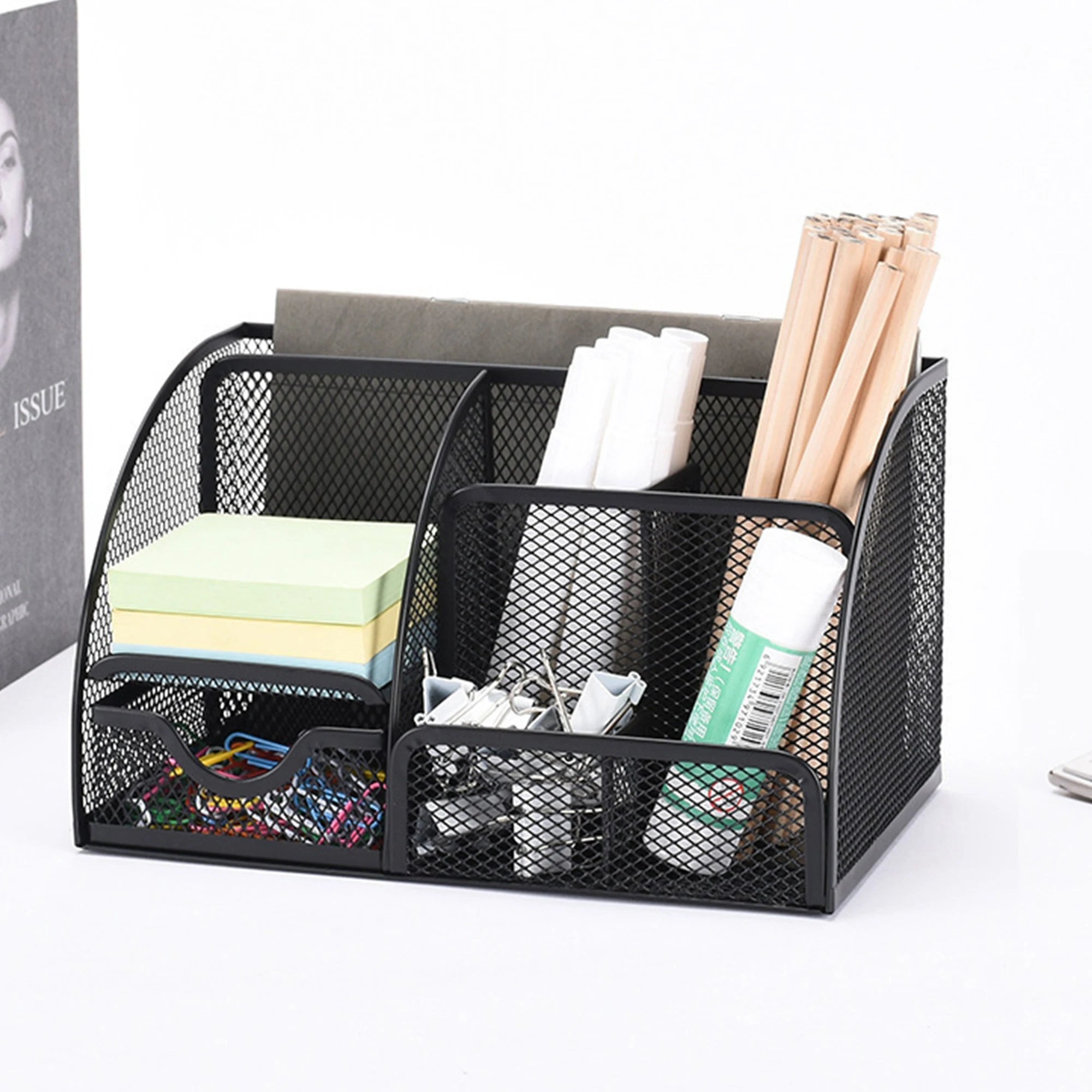 Black mesh desk organizer with office supplies on a white background