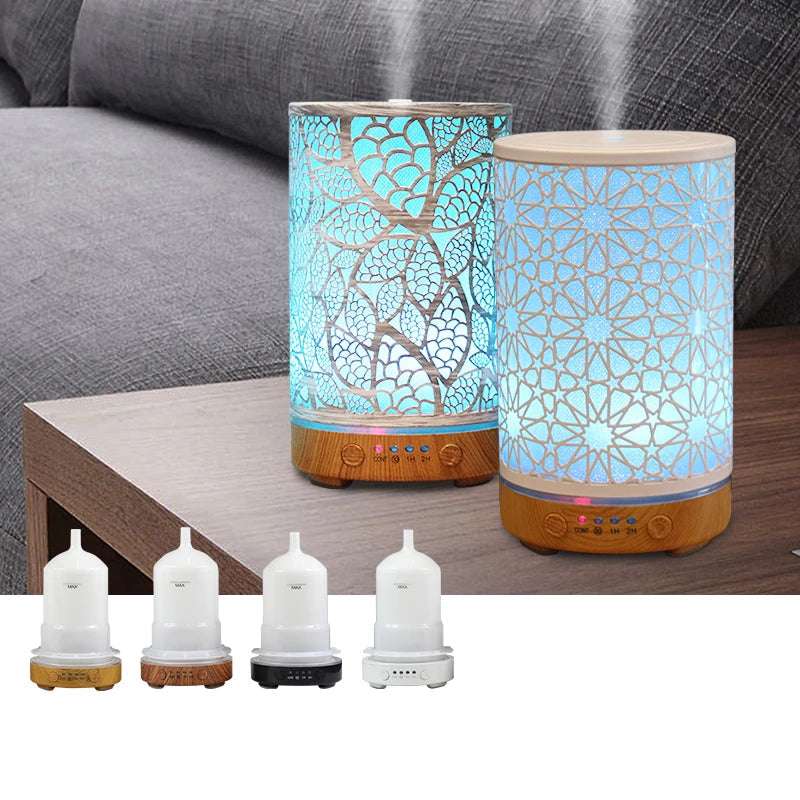 Two aroma humidifiers with decorative glass designs on a wooden table, with a gray sofa in the background.