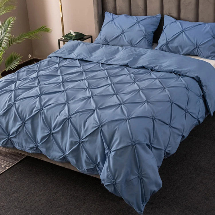 Blue 3D pinch pleated duvet cover set on a modern bed with matching pillowcases.