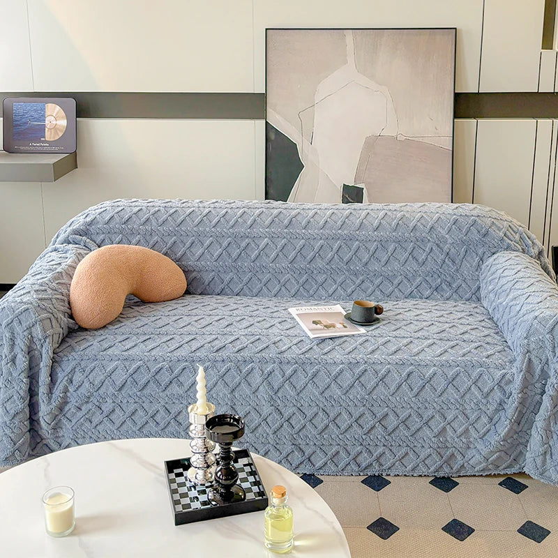 Living room with a blue textured sofa, small table with decorative items, and abstract art on the wall.