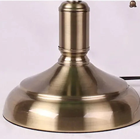 Green glass banker-style desktop lamp with antique brass metal base and pull-chain detail