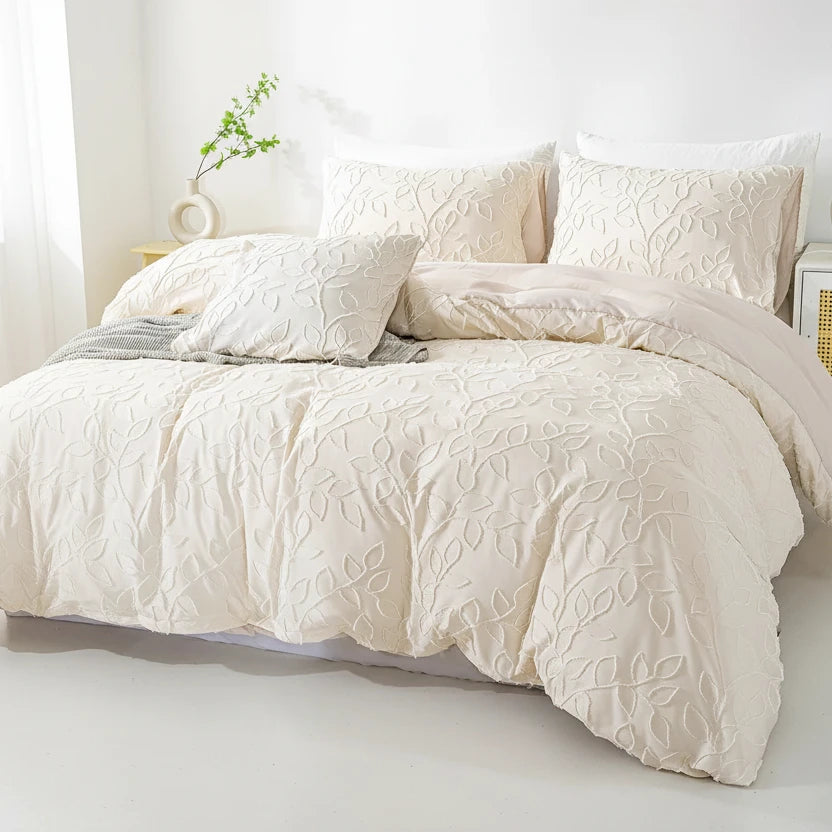 Cream textured comforter set on a bed in a bright room