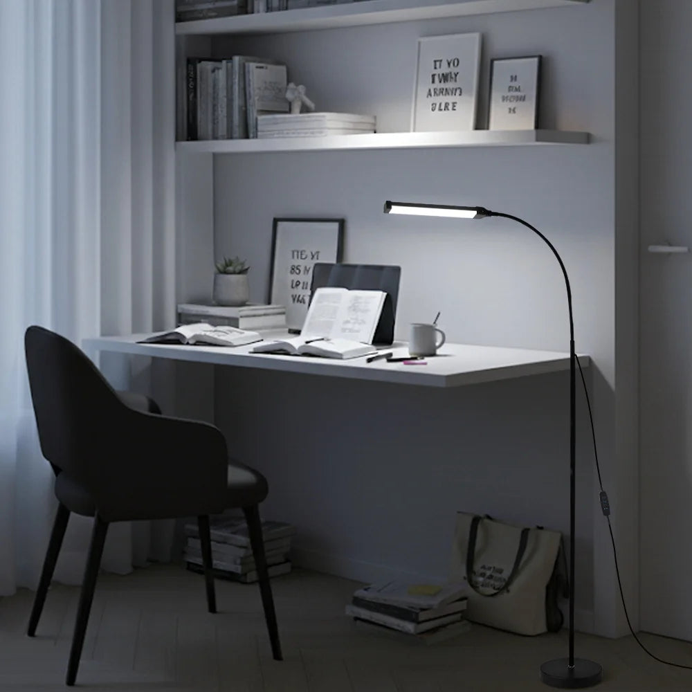Modern home office with a desk, chair, and floor lamp.