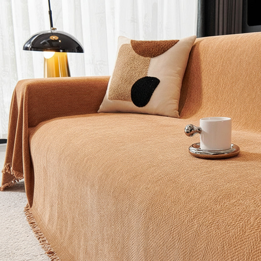 Sandstone orange herringbone chenille sofa throw with fringe detail on a modern couch.