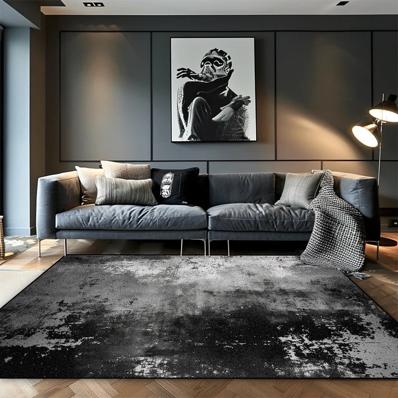 Large black and silver mist abstract area rug with distressed texture in a contemporary dark living room with grey sofa