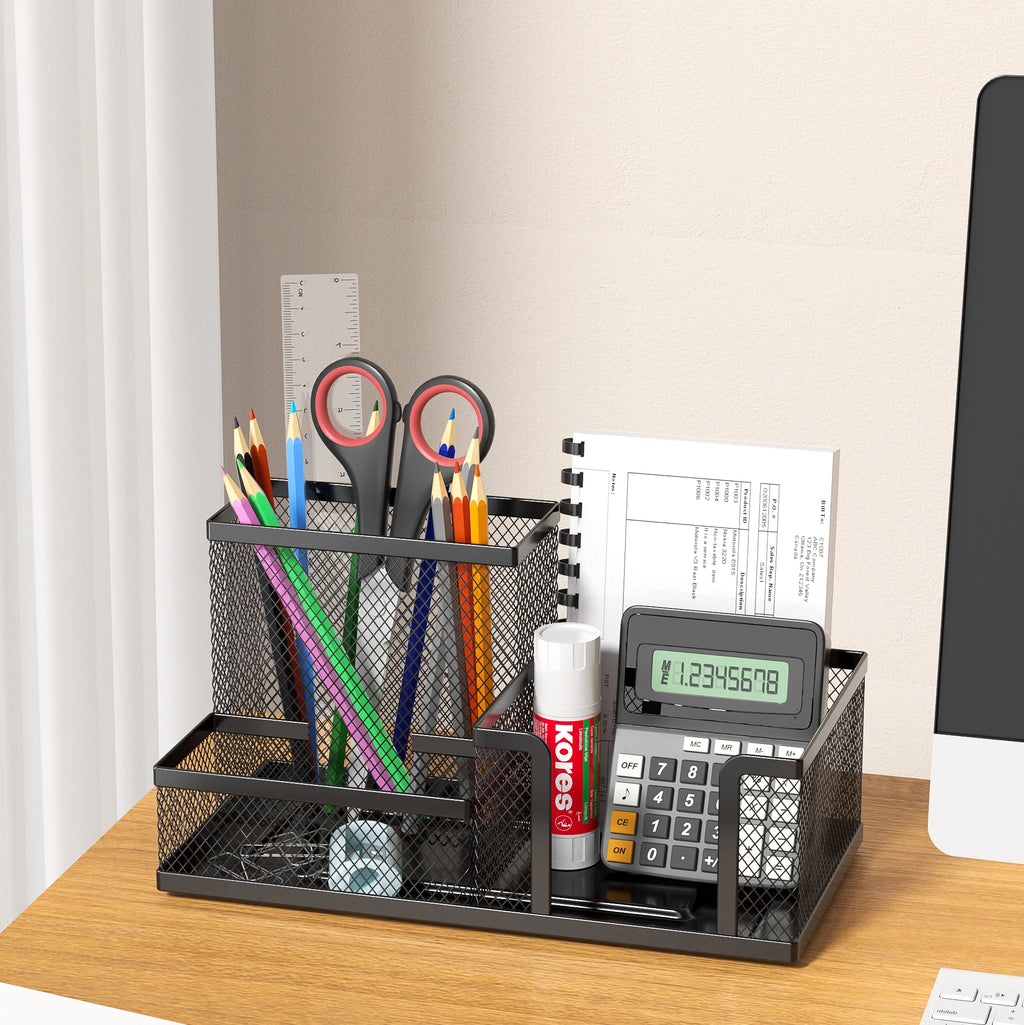 Black mesh desk organizer with stationery items on a wooden desk.