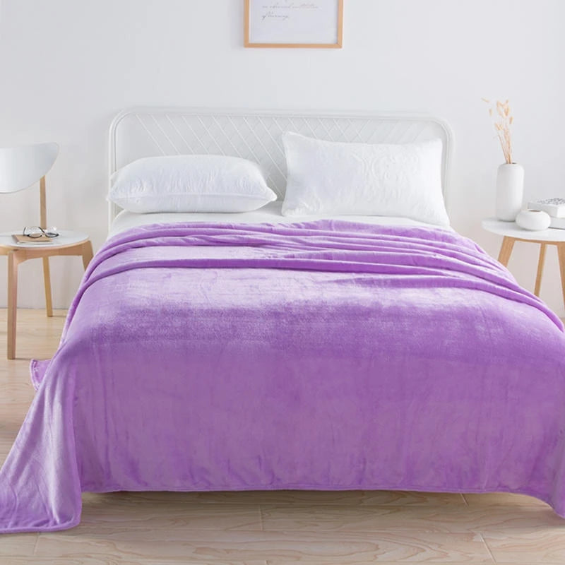 Lavender plush blanket draped over a bed with white pillows