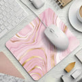 Pink marble mouse pad with gold accents on a desk with a keyboard and mouse.