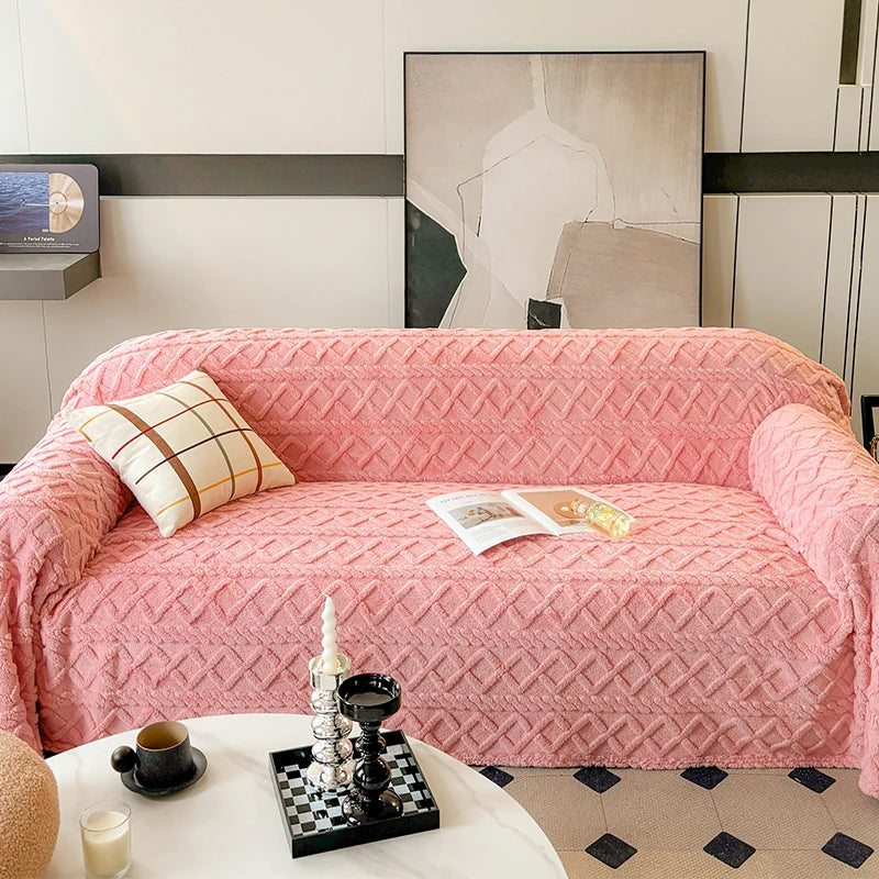 Pink textured sofa with a pillow and magazine in a living room setting.