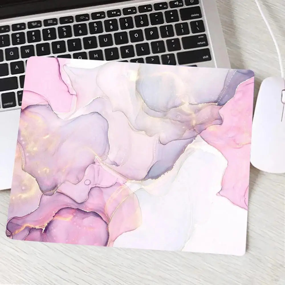Laptop with a pink and purple abstract design on a white surface