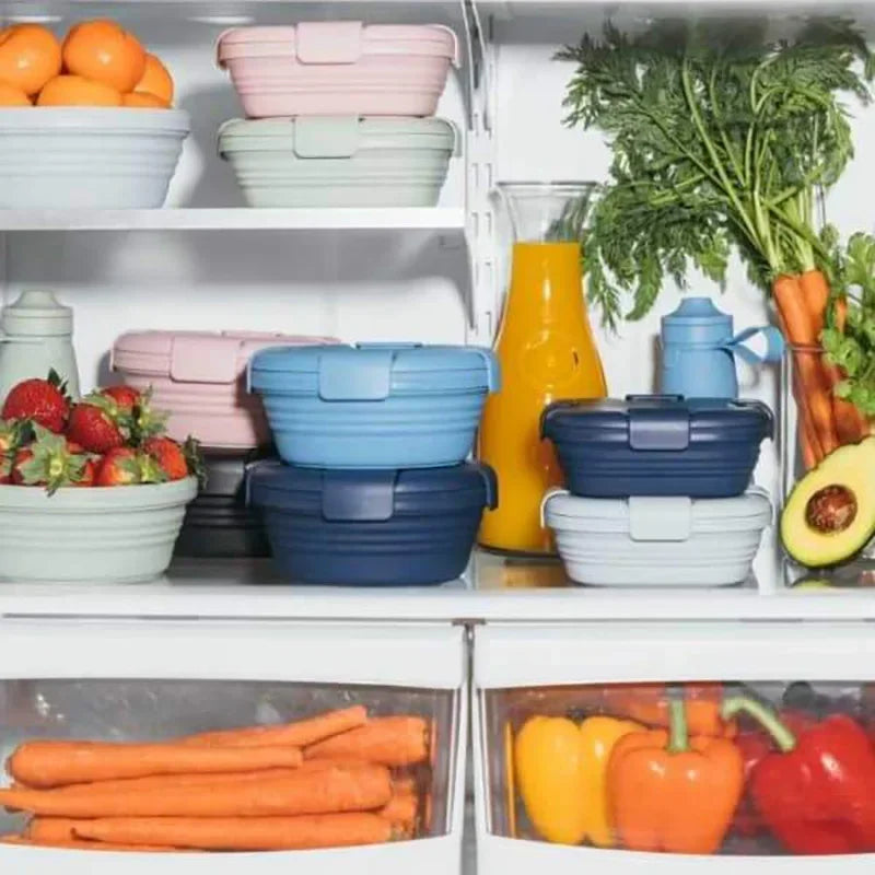Colourful collapsible storage containers in a refrigerator with fruits and vegetables.