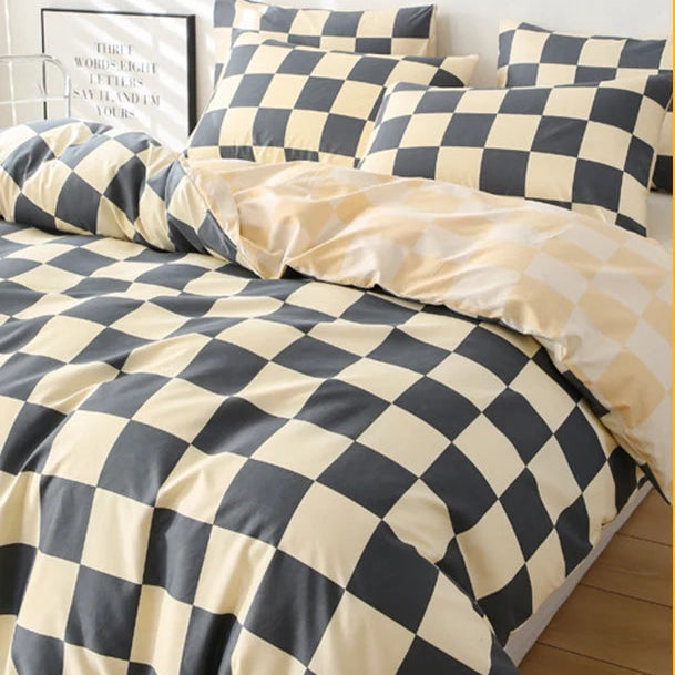Checkered bedspread on a bed with pillows in a bedroom setting.
