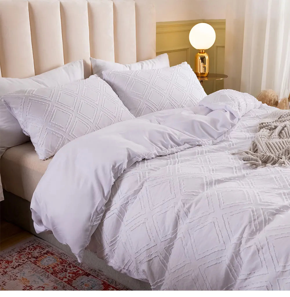 White textured geometric bedding set styled with a throw blanket and upholstered headboard