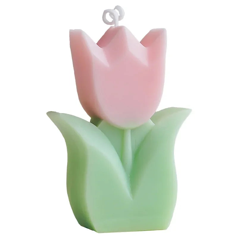 Pink tulip-shaped candle with green base on a white background