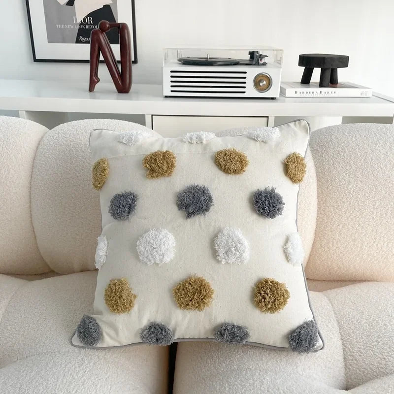 Decorative pillow with pom-pom patterns on a sofa