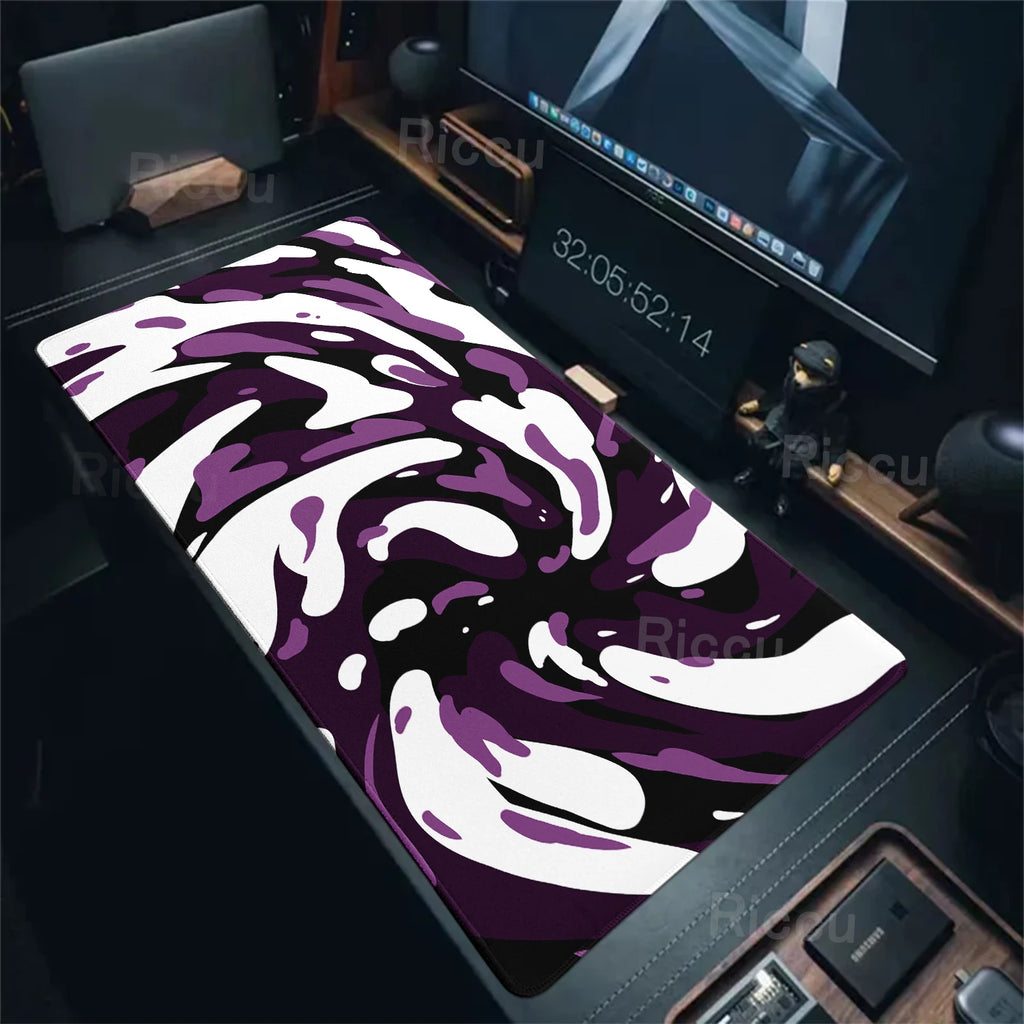 Purple and white camouflage mouse pad on a desk with computer equipment.