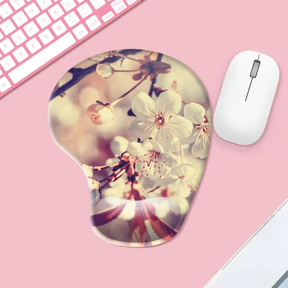Mouse pad with floral design on a pink surface with a computer mouse and keyboard.