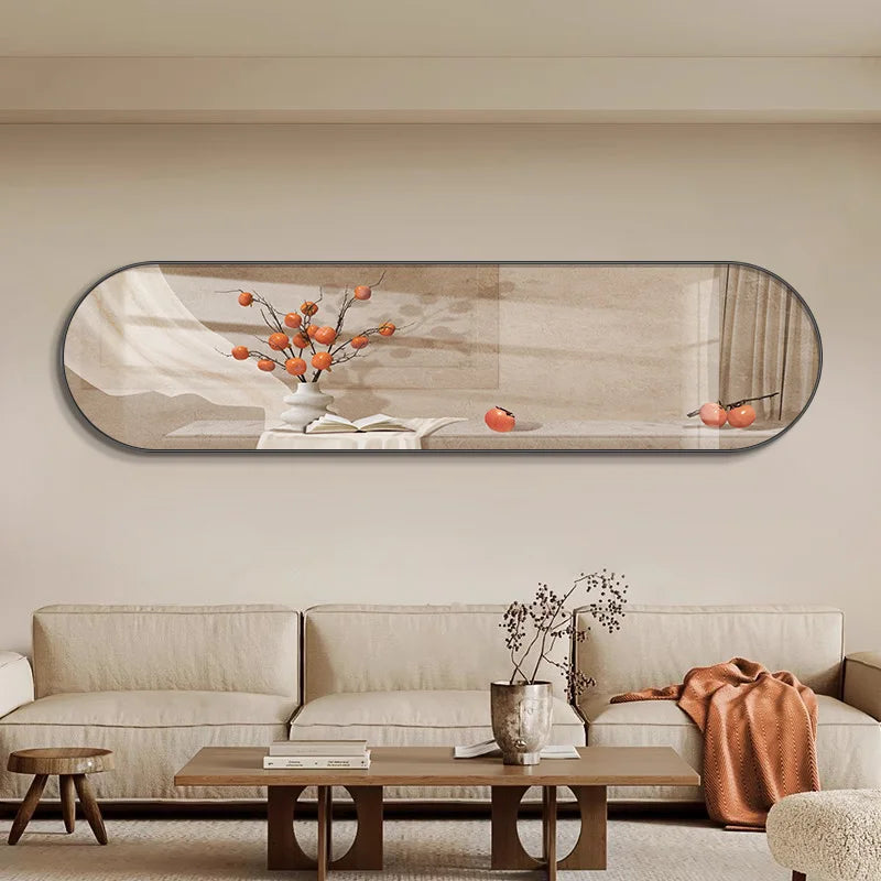 Decorative LED light panel with an oblong shape showing a branch with orange fruit in a white vase, casting a warm ambient light onto a light-coloured wall above a sectional sofa.