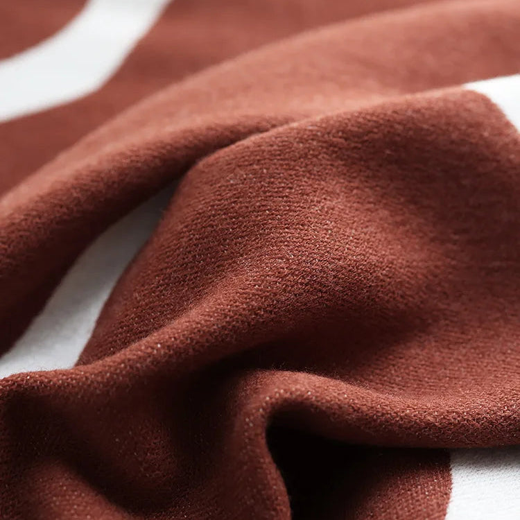 Rust and cream abstract jacquard blanket close-up.