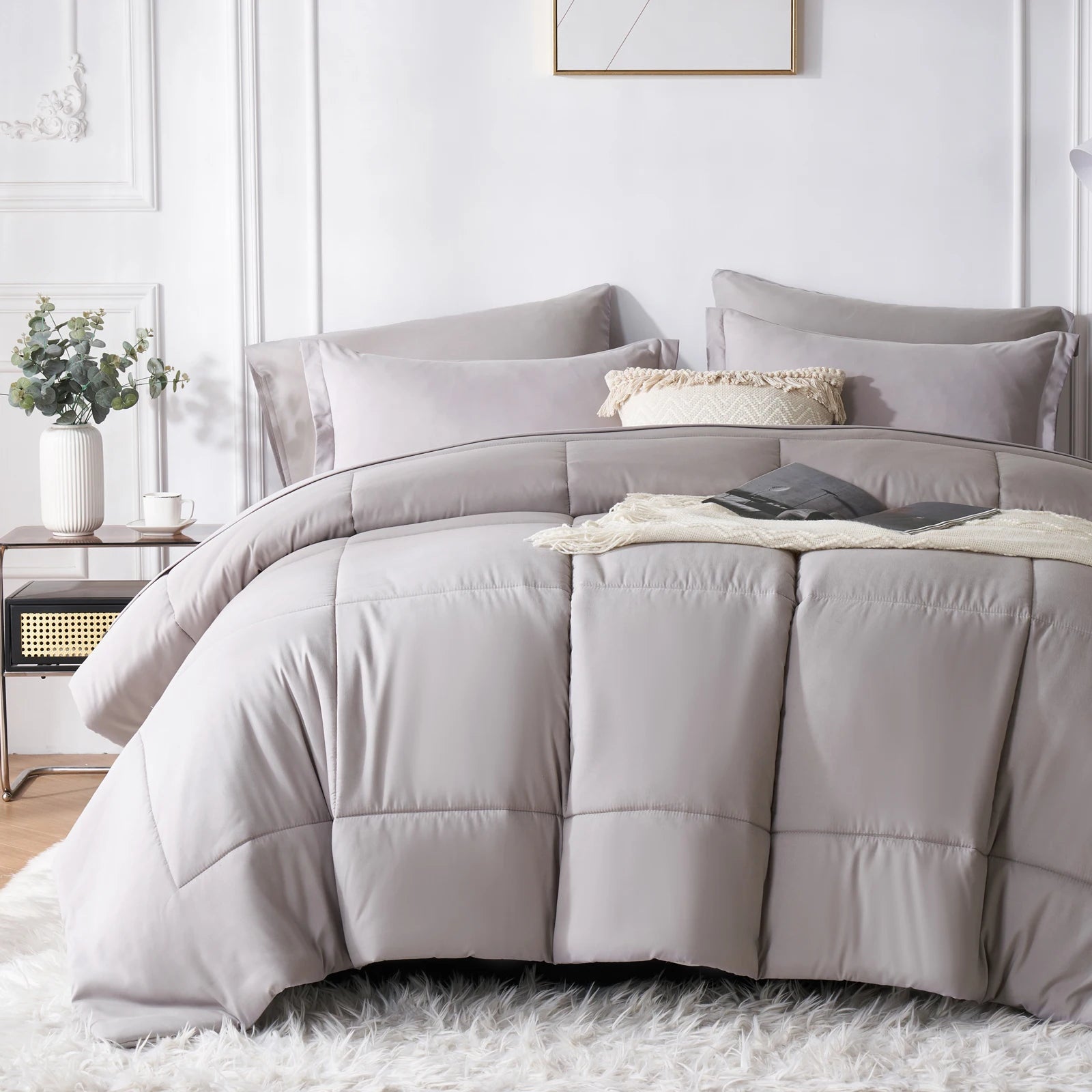 Gray comforter set on a bed in a bedroom setting with decor elements.