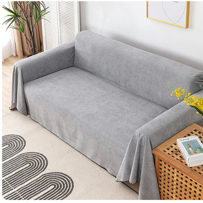 Grey sofa cover on a sofa with a wooden coffee table and decorative elements.